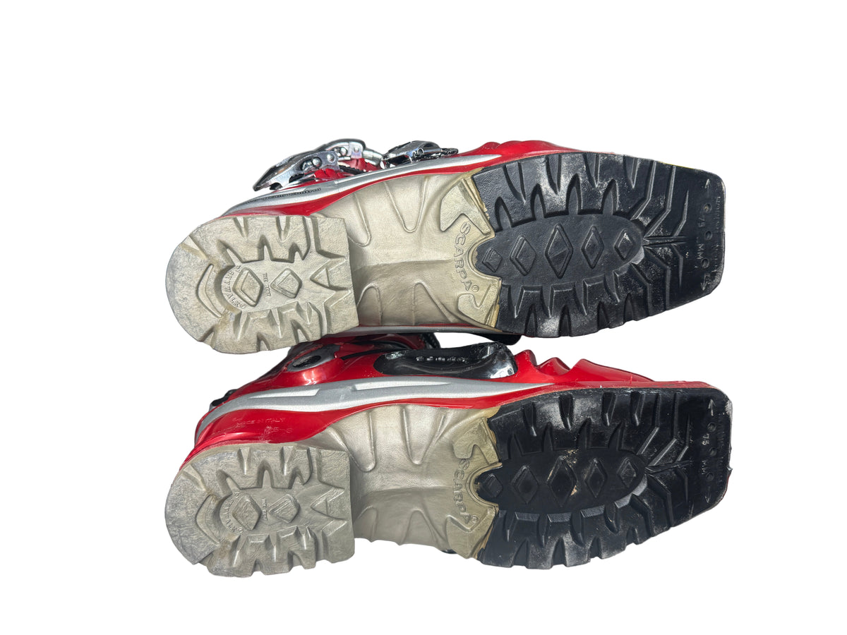 Red and black hiking boots with tread patterns on a white surface.
