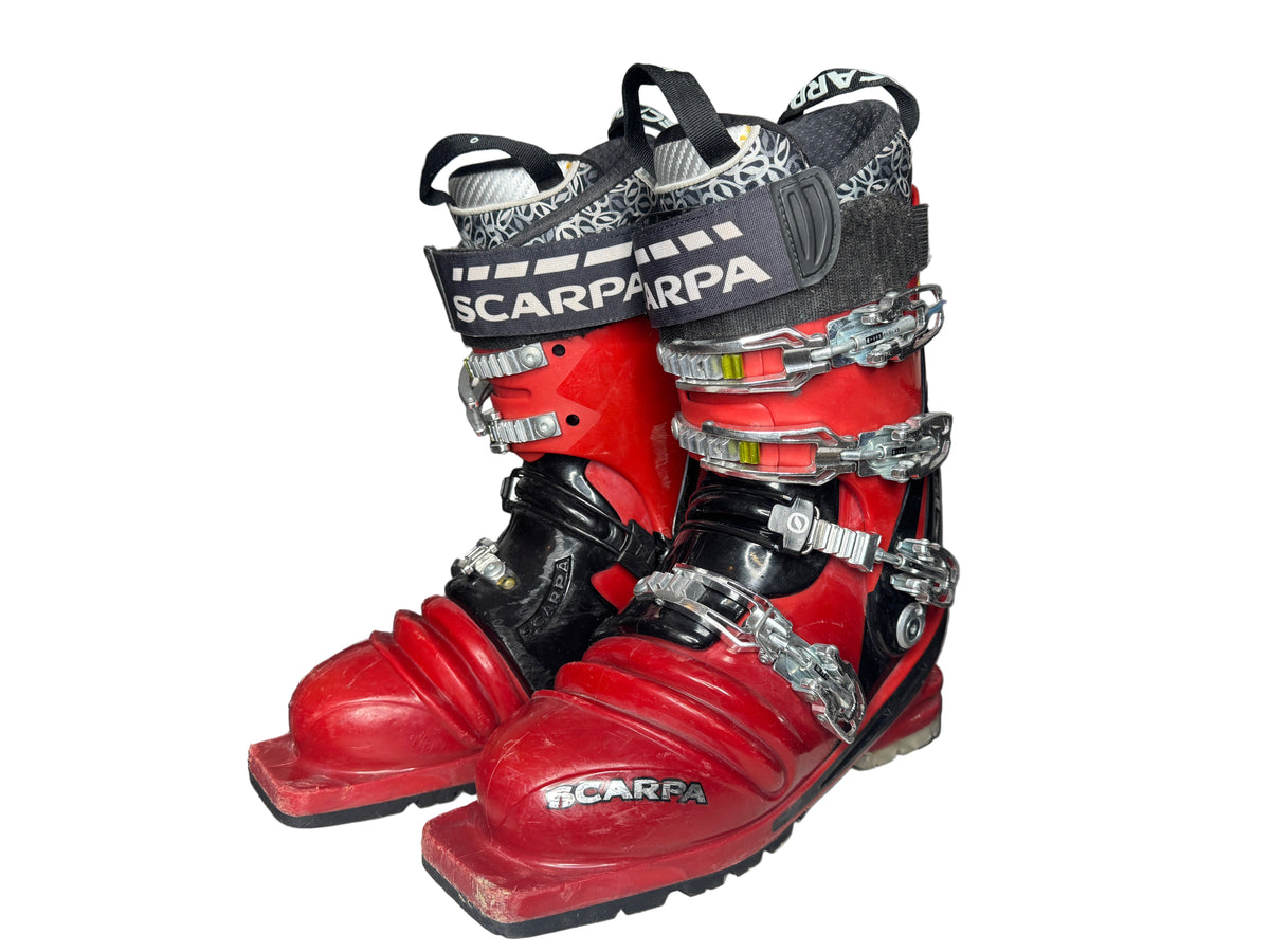 Red and black ski boots with 'Scarpa' branding on a white surface.